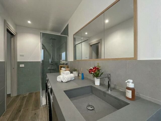 Bagno con lavabo integrato in resina grigia e fiori