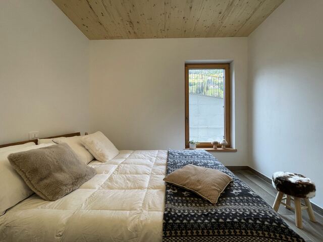 Camera con letto matrimoniale e plaid geometrico