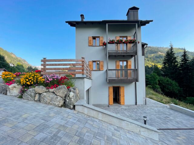 La facciata di Digonera Apartments con i balconi in legno e i fiori sul muretto