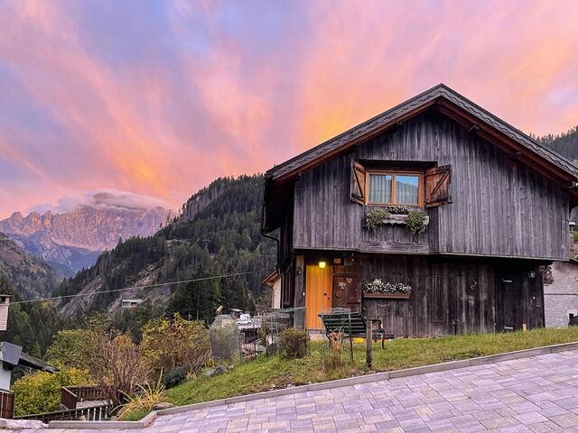 La casa al tramonto con il cielo rosa sopra le Dolomiti