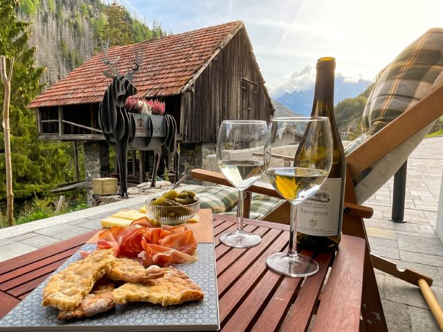 Tagliere di salumi e calici di vino sul tavolo della terrazza